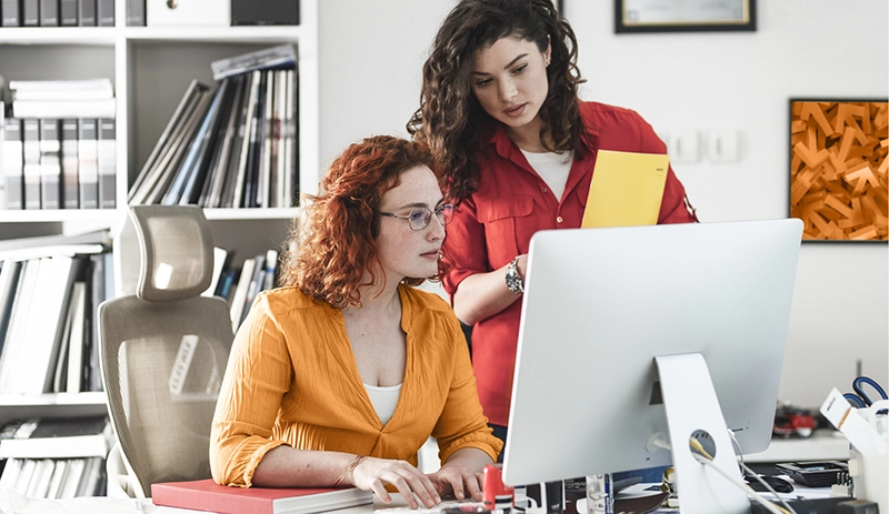 Two women looking at a computer screen